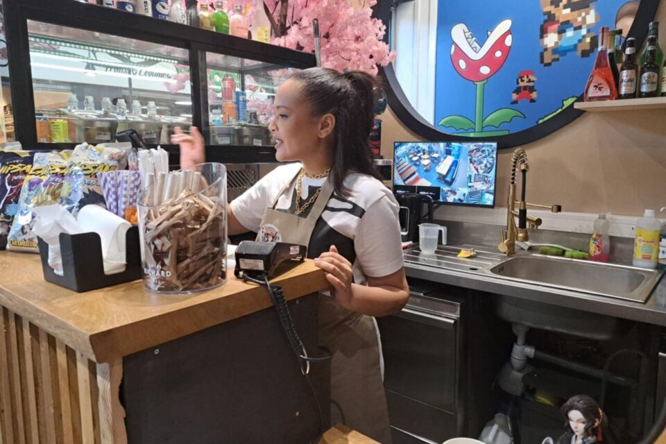 Un membre de l'équipe au comptoir, devant le décor Super Mario